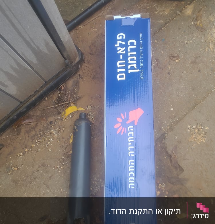 קופסת חלקי דוד שמש וצינור מתכת על הקרקע
